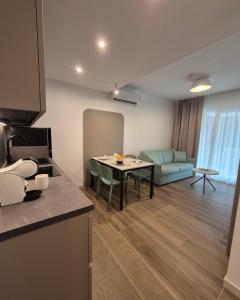 a kitchen and living room with a table and a couch at Libra Aparthotel in Bibione