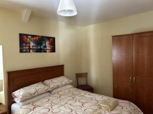 a bedroom with a bed and a wooden cabinet at Number 6 Bank House in Schull