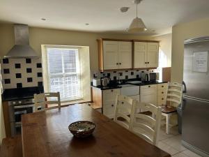 a kitchen with a wooden table and a dining room at Number 6 Bank House in Schull +18 photos