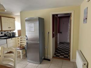 a kitchen with a stainless steel refrigerator and a hallway at Number 6 Bank House in Schull