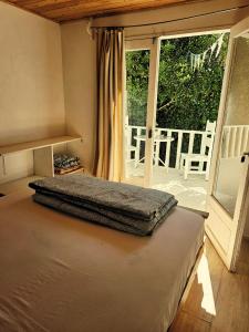 a bedroom with a bed and a large window at Paioneal Hostel l Spa Jacuzzi Sauna in El Quisco