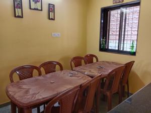 a dining room with tables and chairs and a window at Fulora Guesthouse in Dapoli