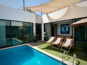 a house with a swimming pool and chairs next to it at "Casa Mosso" en San Felipe del Agua in Oaxaca City