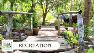 a garden with a wooden bridge and a sign that reads regeneration at Hangin at Agos Resort in Nasugbu +9 photos
