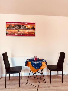 a table with two chairs and a painting on the wall at Golden Oak Guest House in North Leigh