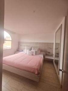 a bedroom with a large bed with pink sheets and a mirror at HOTEL GRAND BOUTIQUE in Fusagasuga +37 photos