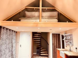 a loft bed in a room with a staircase at Golden Oak Guest House in North Leigh