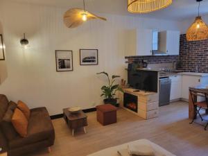 a living room with a couch and a kitchen at studio Anémos in Fécamp