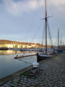 a sail boat is docked at a marina at studio Anémos in Fécamp
