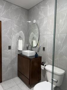 a bathroom with a toilet and a sink and a mirror at Belisario Apartment in Ocotlán