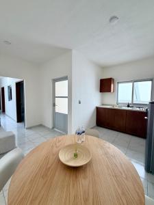 a wooden table in a living room with a kitchen at Belisario Apartment in Ocotlán +4 photos