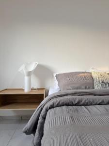 a white bedroom with a bed and a night stand at Belisario Apartment in Ocotlán