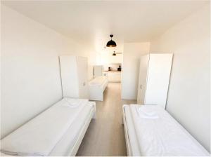 two beds in a room with white cabinets at CityNest Apartment Dortmund in Dortmund