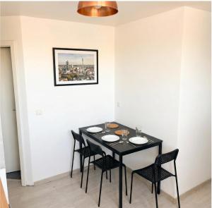 a dining room with a black table and chairs at CityNest Apartment Dortmund in Dortmund
