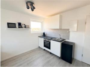 a kitchen with white cabinets and a sink and a window at CityNest Apartment Dortmund in Dortmund