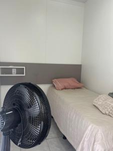 a room with a fan next to two beds at Loft J&C 01 in Primavera do Leste