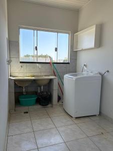 a bathroom with a sink and a tub and a window at Loft J&C 01 in Primavera do Leste