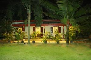 a house with palm trees in front of it at Muraaya in Habaraduwa Central