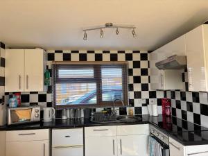 a kitchen with a black and white checkered wall at g11 chalet in Mablethorpe +1 photo