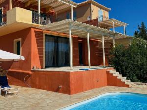 a house with a swimming pool in front of a house at Sea View Villa Irene - Private Pool and Sunset Terrace in Evretí