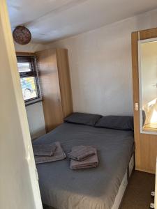 a small bedroom with a bed with towels on it at g11 chalet in Mablethorpe