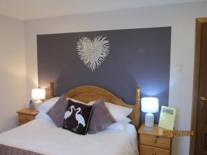 a bedroom with a bed with a heart on the wall at Broomlea in Inverness +31 photos