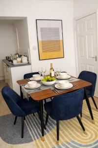 a dining room with a wooden table and blue chairs at Large 4 bedroom house for Contractors, Large groups or Retreat sleeps 8 people in Durham - NO Smoking Indoor House in Edmondsley