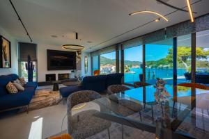 a living room with a glass table and some chairs at Luxury Seafront Villa Aman Korcula with Pool in Korčula