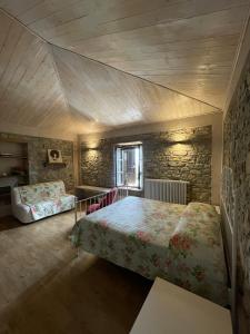a bedroom with two beds and a stone wall at B&B Casa Lupi in Ronchi +49 photos