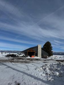 a black building with a fire in the snow at Yellowstone Springs Resort in Island Park