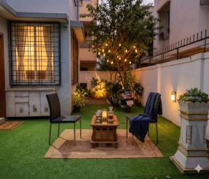a patio with a table and chairs on a lawn at Tejas Grand villa baner in Pune