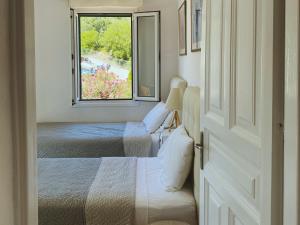two beds in a small room with a window at Sea View Villa Irene - Private Pool and Sunset Terrace in Evretí +44 photos