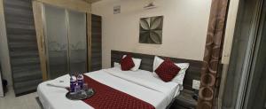 a bedroom with a bed with red pillows at Tejas Grand villa baner in Pune