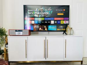 a tv on top of a white cabinet in a living room at Downtown Studio Free Parking 1 mi to Beach & Convention Center in Long Beach