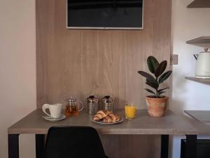 a table with a plate of croissants and coffee and a plant at Refugio - Suite privada con jardín y parrilla en Chilecito in Chilecito