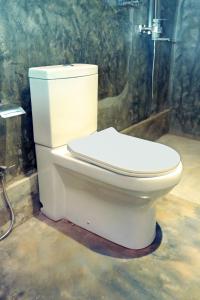 a white toilet in a bathroom with a shower at Muraaya in Habaraduwa Central
