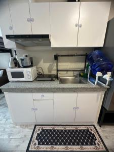 a kitchen with white cabinets and a sink at Minglanilla Condo with Pool, Gym & Fast WiFi in Minglanilla