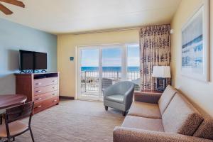 a living room with a couch and a television at Reges Oceanfront Resort in Wildwood Crest