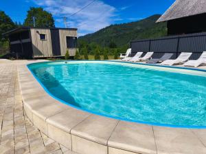 a swimming pool with chairs and a house at Славський Двір in Slavske