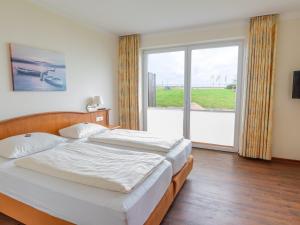 a bedroom with a bed and a large window at Hof Sierksdorf in Sierksdorf
