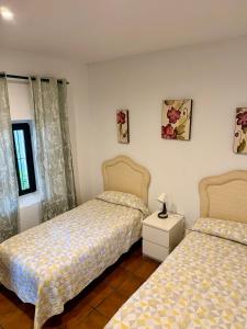a bedroom with two beds and a table with a lamp at Cortijo Majada de las Vacas in Santa Olalla del Cala +24 photos
