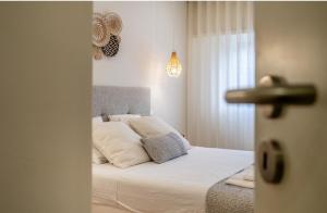 a bedroom with a bed with white sheets and pillows at Brisa do Mar in Quarteira