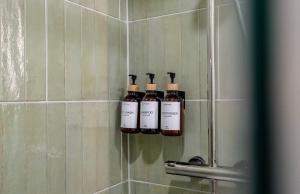 four bottles of wine are on a wall in a shower at Brisa do Mar in Quarteira +15 photos