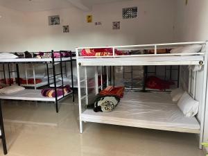 a room with three bunk beds in a room at The rest point dormitory in Khātu
