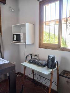 a kitchen with a table with a microwave on it at Departamento Independiente con Terraza in La Cieneguita