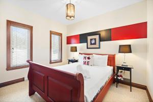 a bedroom with a bed with red and black stripes at Townhouse On The Golf La Bte -10min To Tremblant in Mont-Tremblant