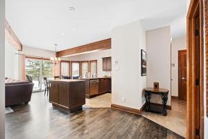 an open kitchen and living room with wooden floors at Townhouse On The Golf La Bte -10min To Tremblant in Mont-Tremblant