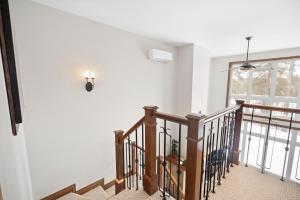 a staircase in a home with white walls at Townhouse On The Golf La Bte -10min To Tremblant in Mont-Tremblant
