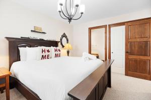 a bedroom with a large bed and a wooden cabinet at Townhouse On The Golf La Bte -10min To Tremblant in Mont-Tremblant +25 photos