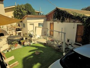 a backyard of a house with a green lawn at Paioneal Hostel l Spa Jacuzzi Sauna in El Quisco